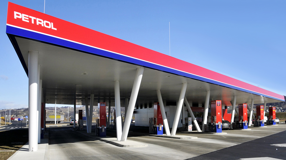 Petrol benzinska stanica sa više točilica pod velikom nadstrešnicom, fotografisana po sunčanom danu.